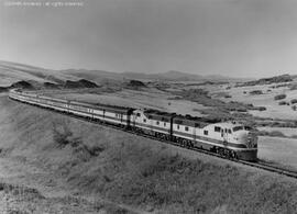 Great Northern diesel locomotive 503 leads a passenger train near Marias Pass, Montana.  Other su...