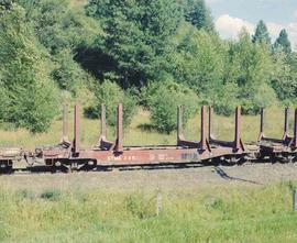 Empty Log Cars Travel Along The St. Maries River Railroad Near Mashburn, Idaho in August 1982.